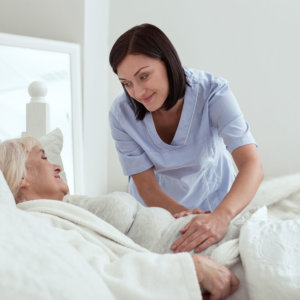 woman smiling with senior in bed