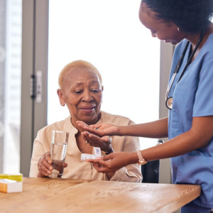 woman giving medicine to senior